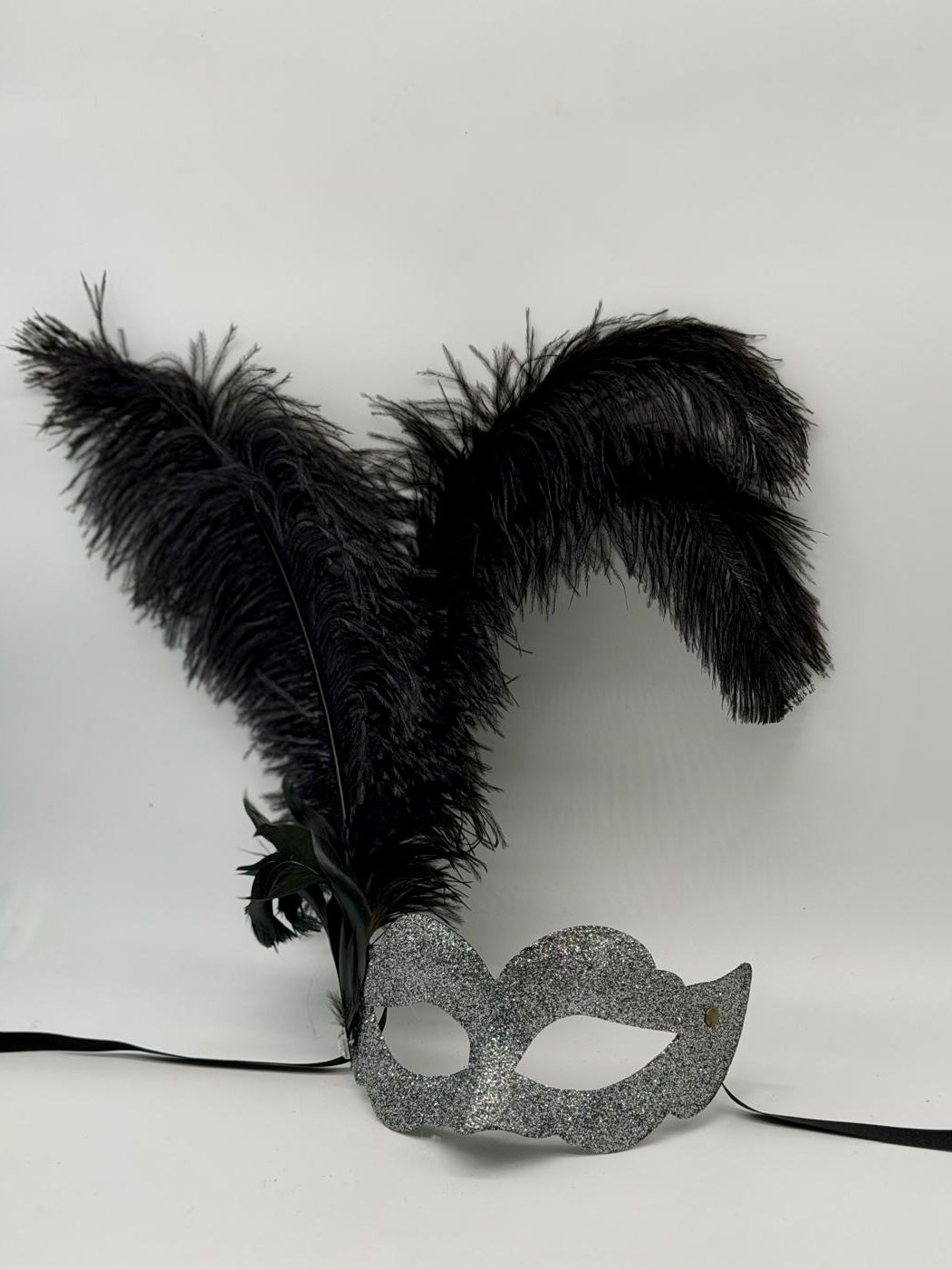 Venezianische Maske aus silbernem Glitzer mit schwarzen Federn