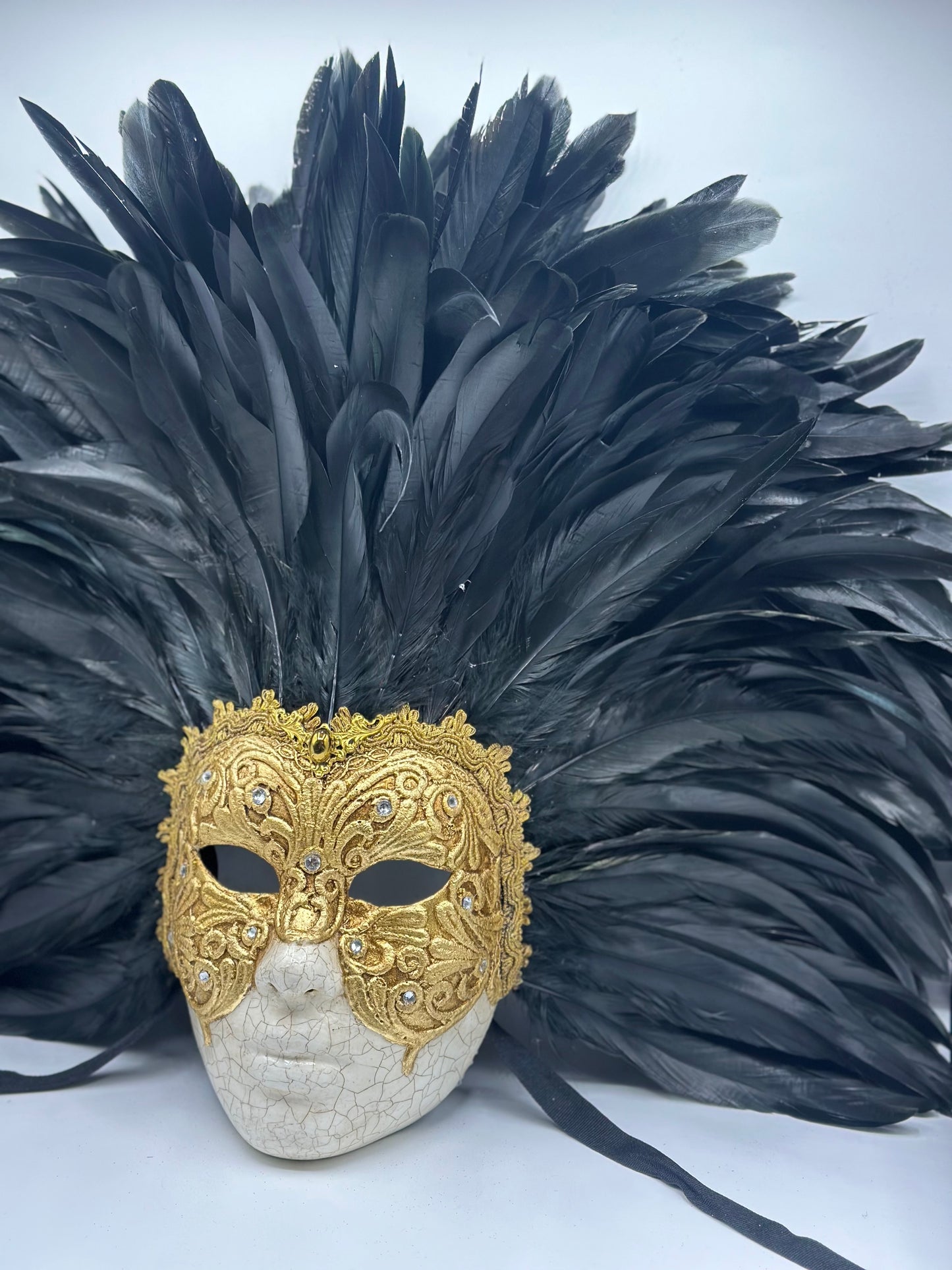 Gouden gezichtsmasker met veren